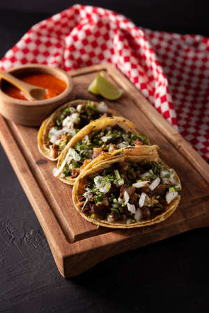 Tacos from Suadero. Fried meat in a corn tortilla. Street food from CDMX, Mexico, traditionally accompanied with cilantro, onion and spicy red sauceの写真素材