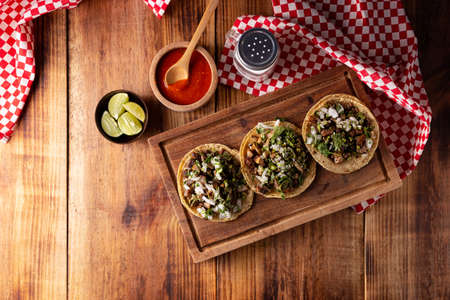 Tacos from Suadero. Fried meat in a corn tortilla. Street food from CDMX, Mexico, traditionally accompanied with cilantro, onion and spicy red sauceの写真素材