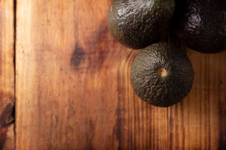 Mexican avocado (persea americana) on rustic wooden table. Main ingredient to prepare guacamole. Flat Lay image with copy space.の写真素材