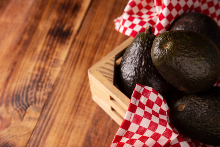 Mexican avocado (persea americana) on rustic wooden table. Main ingredient to prepare guacamole. Close up image with copy space.の写真素材