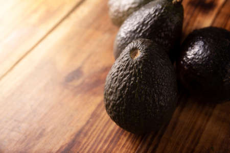 Mexican avocado (persea americana) on rustic wooden table. Main ingredient to prepare guacamole. Close up image with copy space.の写真素材