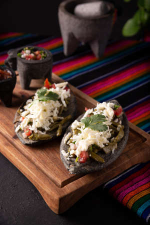 Homemade Tlacoyos with Nopales. Mexican pre hispanic dish made of blue corn flour patty filled with fried beans. Popular street food in Mexico.の写真素材