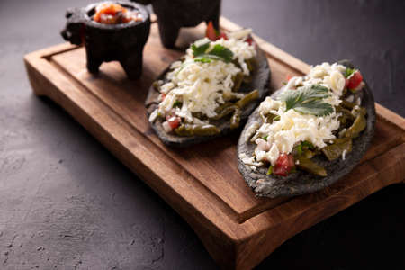 Tlacoyos and Nopales. Mexican pre hispanic dish made of blue corn flour patty filled with fried beans. Popular street food in Mexico.の写真素材