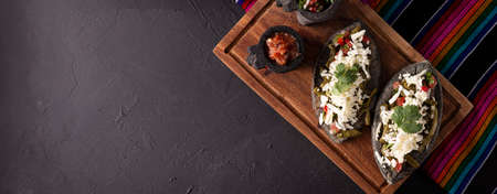 Mexican Tlacoyos. Mexican pre hispanic dish made of blue corn flour patty filled with fried beans. Popular street food in Mexico. Panoramic image with copy space. top viewの写真素材