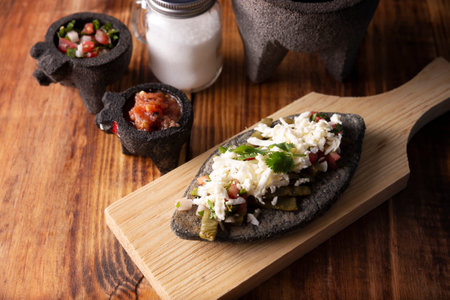 Tlacoyos with Nopales and salsa. Mexican pre hispanic dish made of blue corn flour patty filled with fried beans. Popular street food in Mexico.の写真素材
