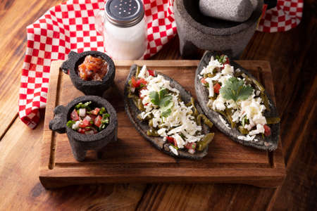 Tlacoyos with Nopales and Cheese. Mexican pre hispanic dish made of blue corn flour patty filled with fried beans. Popular street food in Mexico.の写真素材
