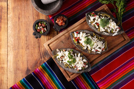 Tlacoyos. Mexican pre hispanic dish made of blue corn flour patty filled with fried beans. Popular street food in Mexico. Flat lay image with copy space.の写真素材