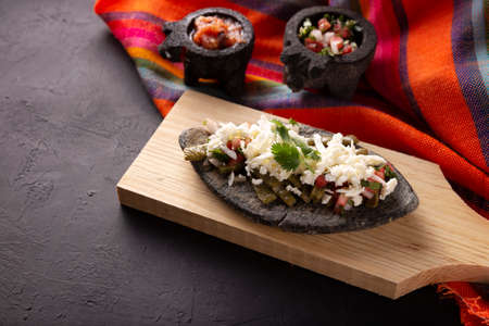 Tlacoyo with Nopales and salsa. Mexican pre hispanic dish made of blue corn flour patty filled with fried beans. Popular street food in Mexico.の写真素材