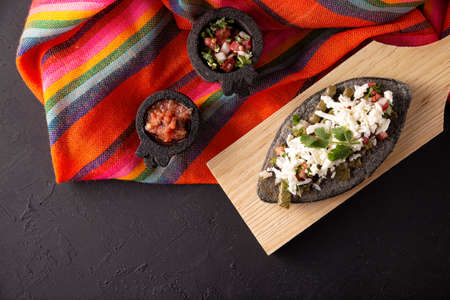 Tlacoyo with Nopales and Cheese. Mexican pre hispanic dish made of blue corn flour patty filled with fried beans. Popular street food in Mexico. Top view.の写真素材