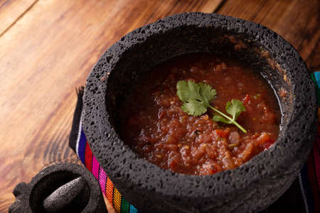 Red Molcajete Sauce. Traditional mexican version of mortar and pestle handmade of volcanic stone. Essential element in the preparation of the authentic Mexican sauceの写真素材