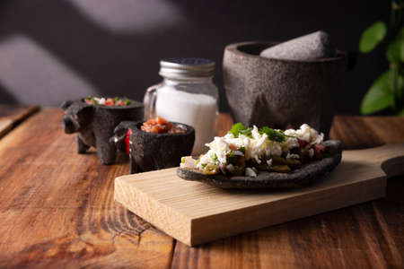 Tlacoyo with Nopales and salsa. Mexican pre hispanic dish made of blue corn flour patty filled with fried beans. Popular street food in Mexico.の写真素材