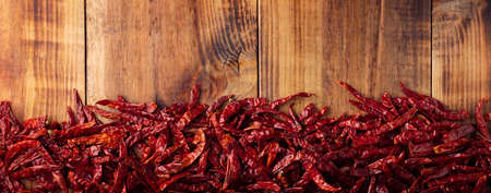 Chile de Arbol on wooden background. This potent Mexican chili can be used fresh, powdered or dried in a variety of Mexican dishes. panorama top viewの写真素材