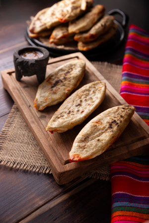 Tlacoyos. Mexican pre-Hispanic dish made of corn flour patty filled with chicharron pressed (pressed pork rinds). Popular street food in Mexico.の写真素材