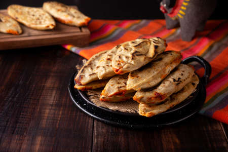 Tlacoyos. Mexican pre-Hispanic dish made of corn flour patty filled with chicharron pressed (pressed pork rinds). Popular street food in Mexico.の写真素材