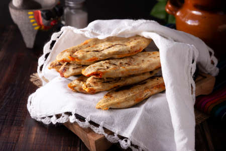 Tlacoyos. Mexican pre-Hispanic dish made of corn flour patty filled with chicharron pressed (pressed pork rinds). Popular street food in Mexico.の写真素材