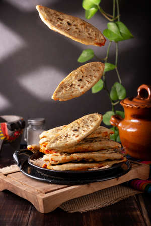 Tlacoyos. Mexican pre-Hispanic dish made of corn flour patty filled with chicharron pressed (pressed pork rinds). Popular street food in Mexico. levitation photographyの写真素材
