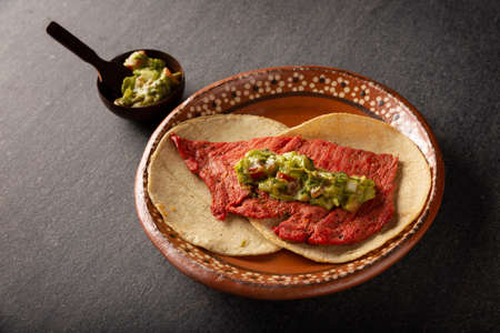 Cecina Enchilada Tacos with Guacamole. Salted, sun-dried pork or beef meat, seasoned with various spices and chili peppers, usually eaten in tacosの写真素材