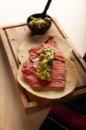 Cecina Enchilada Tacos with Guacamole. Salted, sun-dried pork or beef meat, seasoned with various spices and chili peppers, usually eaten in tacosの写真素材