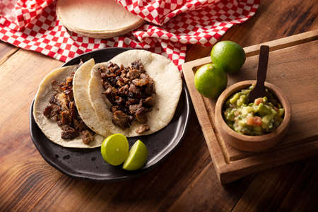 Steak tacos. Homemade grilled meat in a corn tortilla. Street food from Mexico, traditionally accompanied with cilantro, onion and spicy sauce or guacamoleの写真素材