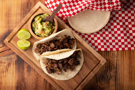 Steak tacos. Homemade grilled meat in a corn tortilla. Street food from Mexico, traditionally accompanied with cilantro, onion and spicy sauce or guacamoleの写真素材