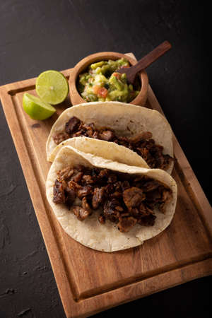Steak tacos. Homemade grilled meat in a corn tortilla. Street food from Mexico, traditionally accompanied with cilantro, onion and spicy sauce or guacamoleの写真素材