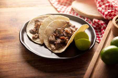 Steak tacos. Homemade grilled meat in a corn tortilla. Street food from Mexico, traditionally accompanied with cilantro, onion and spicy sauce or guacamoleの写真素材