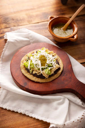 Chicken soup. Traditional homemade Mexican appetizer prepared with fried corn dough covered with chilled beans, green or red sauce, lettuce, cheese, onion and shredded chickenの写真素材