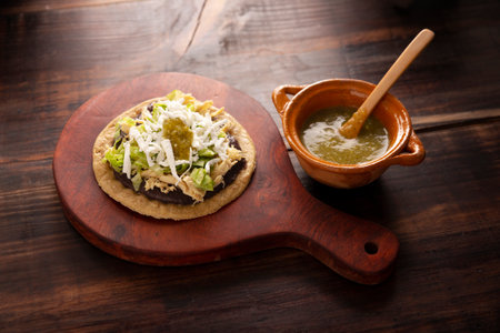 Chicken soup. Traditional homemade Mexican appetizer prepared with fried corn dough covered with chilled beans, green or red sauce, lettuce, cheese, onion and shredded chickenの写真素材