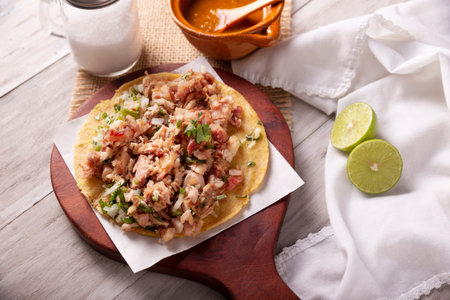 Taco of Carnitas. Cornmeal tortilla with deep fried pork. Traditional Mexican appetizer commonly accompanied by cilantro, onion and hot sauce.の写真素材