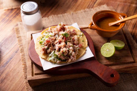 Taco of Carnitas. Cornmeal tortilla with deep fried pork. Traditional Mexican appetizer commonly accompanied by cilantro, onion and hot sauce.の写真素材