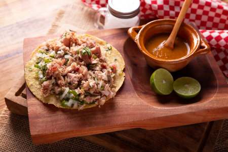 Taco of Carnitas. Cornmeal tortilla with deep fried pork. Traditional Mexican appetizer commonly accompanied by cilantro, onion and hot sauce.の写真素材