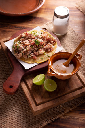 Taco of Carnitas. Cornmeal tortilla with deep fried pork. Traditional Mexican appetizer commonly accompanied by cilantro, onion and hot sauce.の写真素材