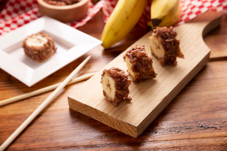 Banana sushi sweet rolls with caramel, peanut butter and chocolate puffed rice. Funny and easy homemade snack for kids and adults.の写真素材