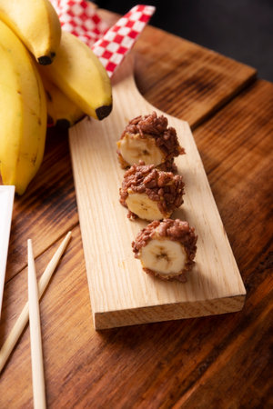 Banana sushi sweet rolls with caramel, peanut butter and chocolate puffed rice. Funny and easy homemade snack for kids and adults.の写真素材