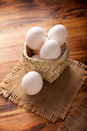 Many white chicken eggs on rustic wooden table. Very popular nutritious and economic food product.の写真素材