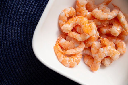 Boiled and peeled shrimp, ready to eat or used as an ingredient in salads, cocktails, toasts and many more recipes. Table top view.の写真素材