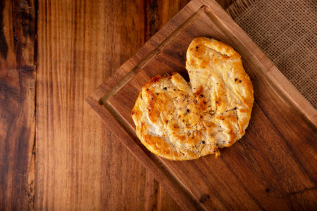 Homemade roasted chicken breast, flattened and seasoned on rustic wooden table. Closeup image.の写真素材