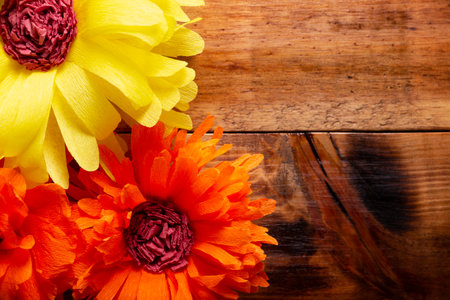 Paper flowers on wooden table background. Decoration floral pattern, springtime, Easter, Birthday, Happy Womens Day, Mothers Day. Copy space for your message. top view.の写真素材