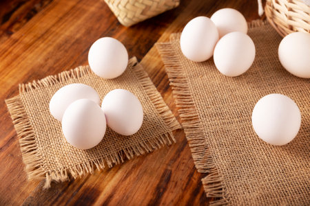 Many white chicken eggs on rustic wooden table. Very popular nutritious and economic food product.の写真素材