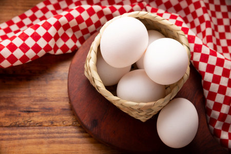 Half a dozen of white chicken eggs on rustic wooden table. Very popular nutritious and economic food product. Table top view image.の写真素材