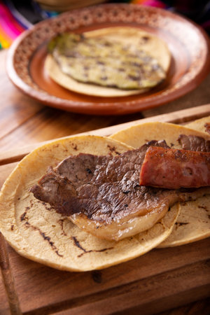Roast meat tacos with Chorizo. Very popular dish in northern Mexico, also called Carne Asada, Asado, Discada or Parrillada, is a cooking technique in which food is exposed to the heat of the embers.の写真素材