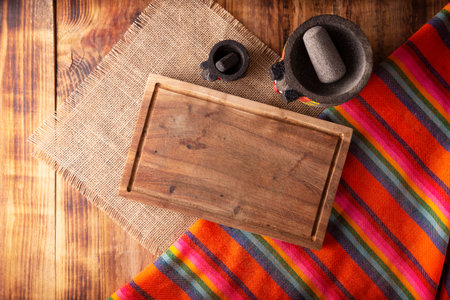 Rustic kitchen concept background. Stone molcajetes and cutting board on rustic wooden table. Table top view.の写真素材