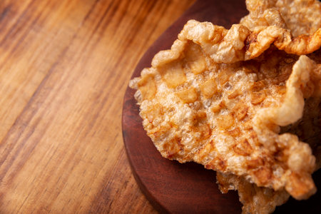 Pork rind. Crispy Fried pork rind, are pieces of aired and fried pork skin, traditional Mexican ingredient or snack served with lime juice and red hot sauce. Closeup.の写真素材