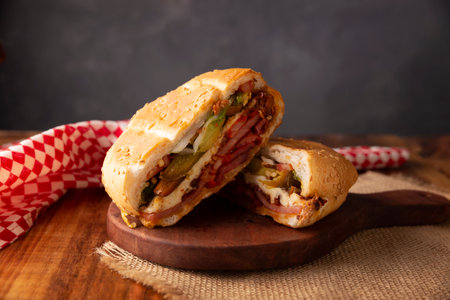Mexican Cake. Sandwich made with common bread in Mexico, it can be telera, bolillo or bagette, split in half and filled with various ingredients, in this case spicy pork leg with Oaxaca cheese.の写真素材