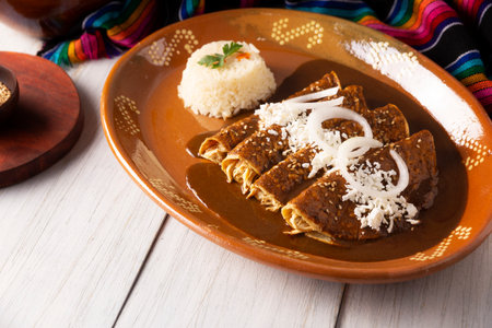 Mole enchiladas. Also known as mole poblano enchiladas, they are a typical Mexican dish that is very popular in Mexico and the rest of the world.の写真素材