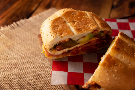 Mexican Cake. Sandwich made with common bread in Mexico, it can be telera, bolillo or bagette, split in half and filled with various ingredients, in this case spicy pork leg with Oaxaca cheese.の写真素材