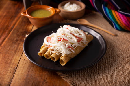 Golden tacos. Mexican dish also known as Flautas, consists of a rolled corn tortilla with some filling, commonly chicken or beef or vegetarian options such as potatoes.の写真素材