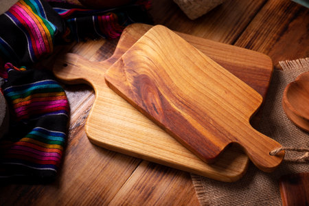 Empty rustic wooden cutting board for kitchen on old wooden table.の写真素材