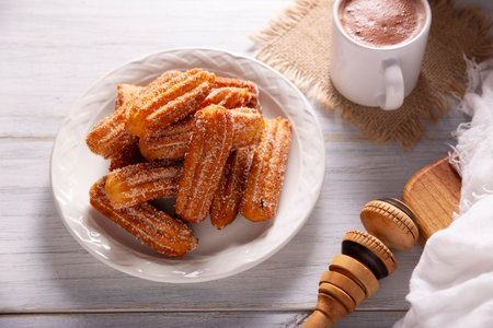 Churros. Fried wheat flour dough, a very popular sweet snack in Spain, Mexico and other countries where it is customary to eat them for breakfast or snack accompanied by hot chocolate or coffee.の写真素材