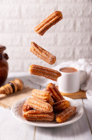 Falling Churros. Fried wheat flour dough, a very popular sweet snack in Spain, Mexico and other countries where it is customary to eat them for breakfast or accompanied by hot chocolate.の写真素材